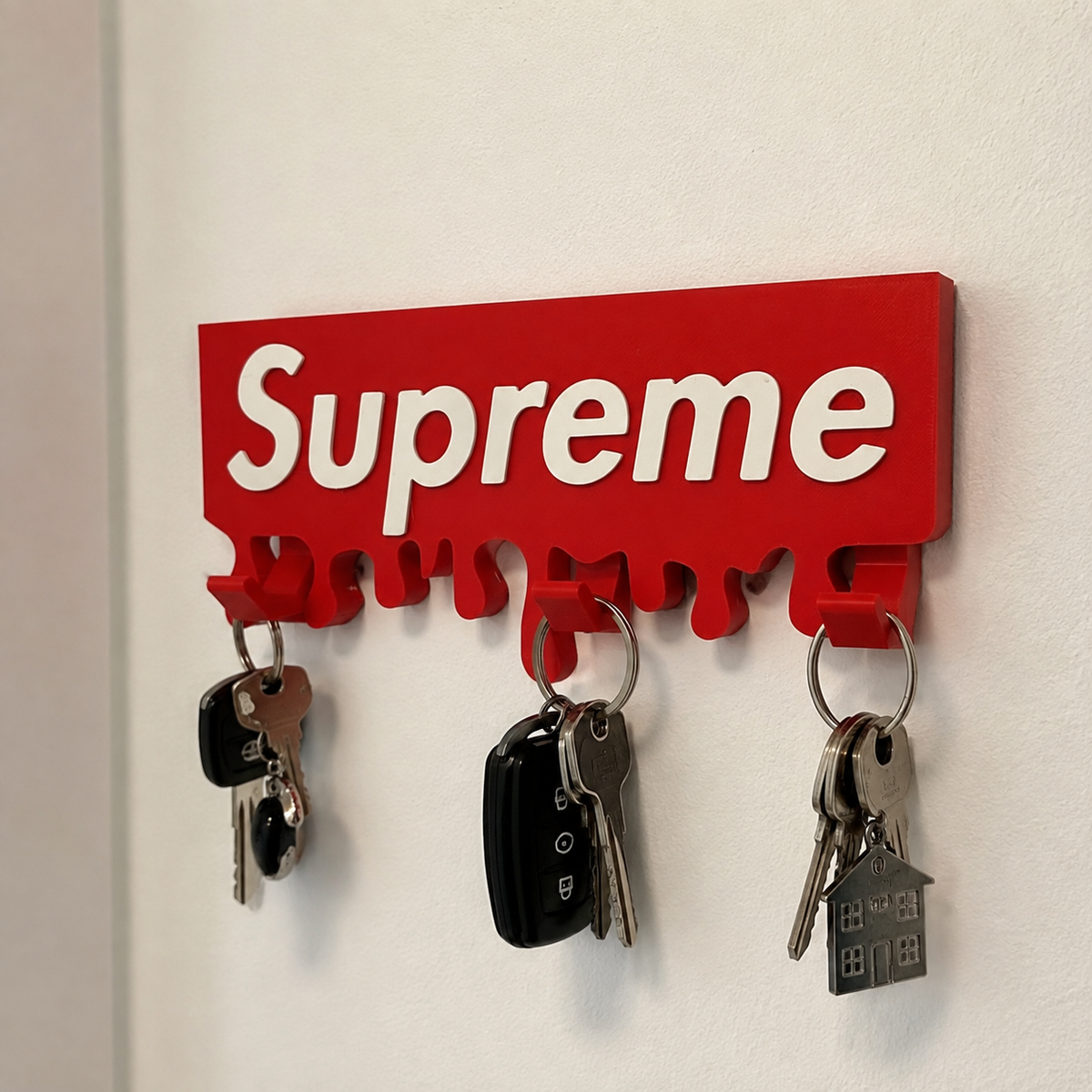 Cuelgallaves de pared estilo Supreme instalado con llaves colgadas en los tres ganchos.