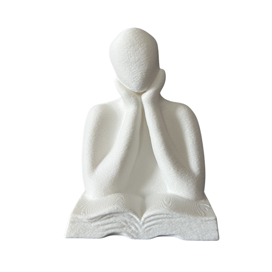 Figura decorativa impresa en 3D de una persona leyendo un libro vista frontal en color blanco.