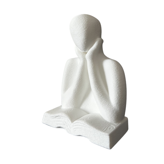 Perspectiva de la figura decorativa impresa en 3D representando una persona leyendo un libro.