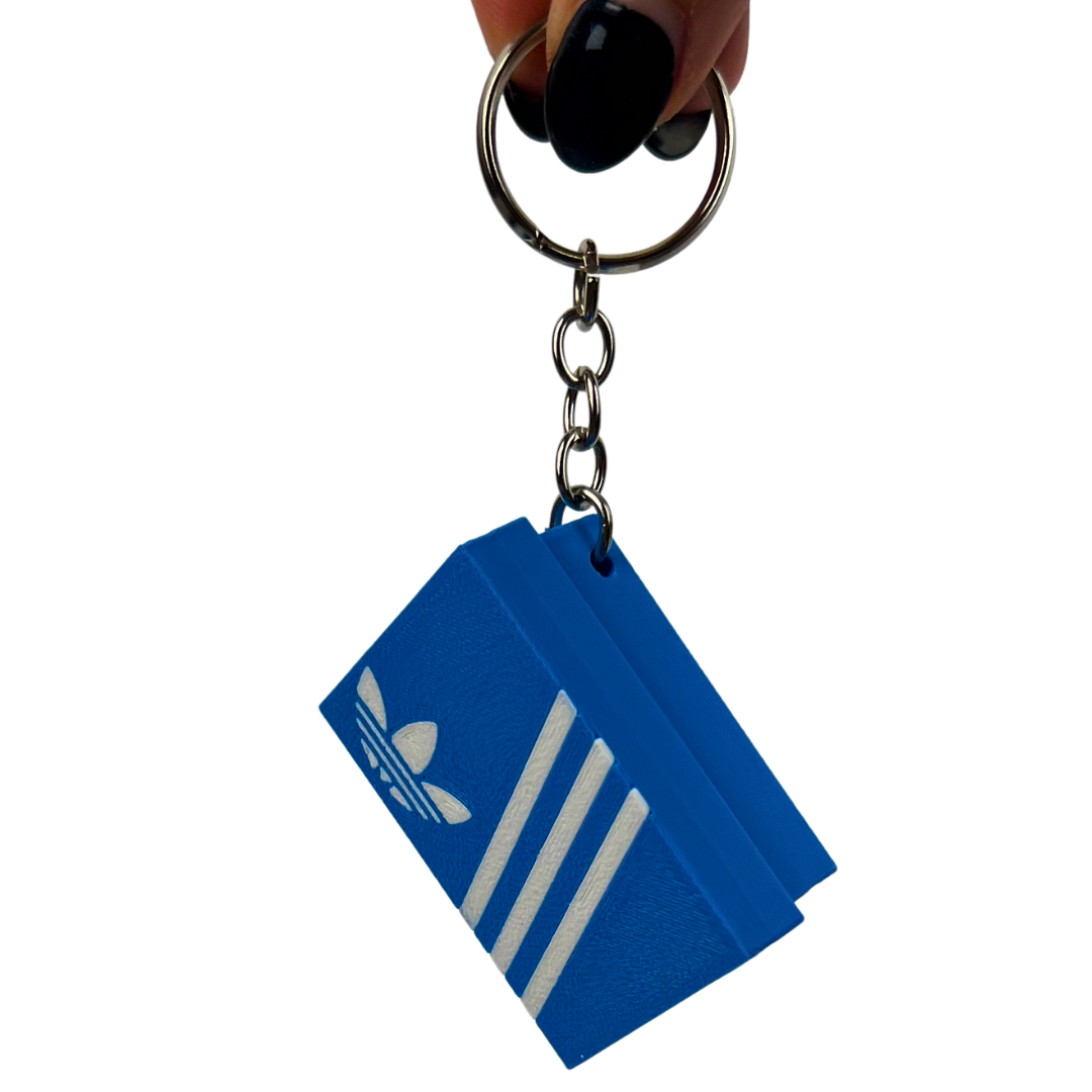 Llavero clicker Beetle Print Retro Stripes colgado para mostrar su tamaño compacto, la cadena metálica y el uso como accesorio