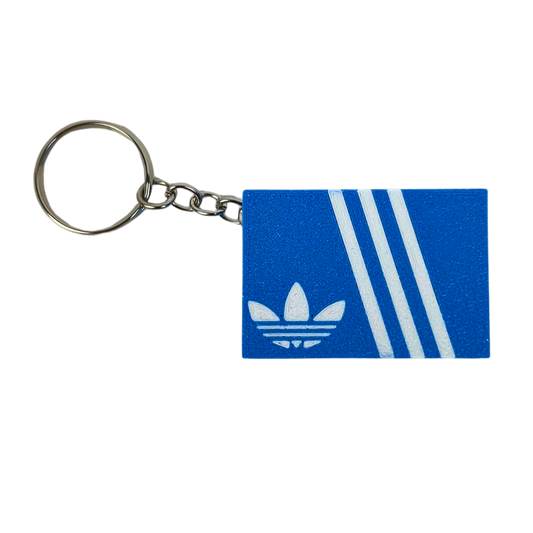 Llavero clicker Beetle Print Retro Stripes mostrado de frente con caja azul, líneas blancas y anilla metálica
