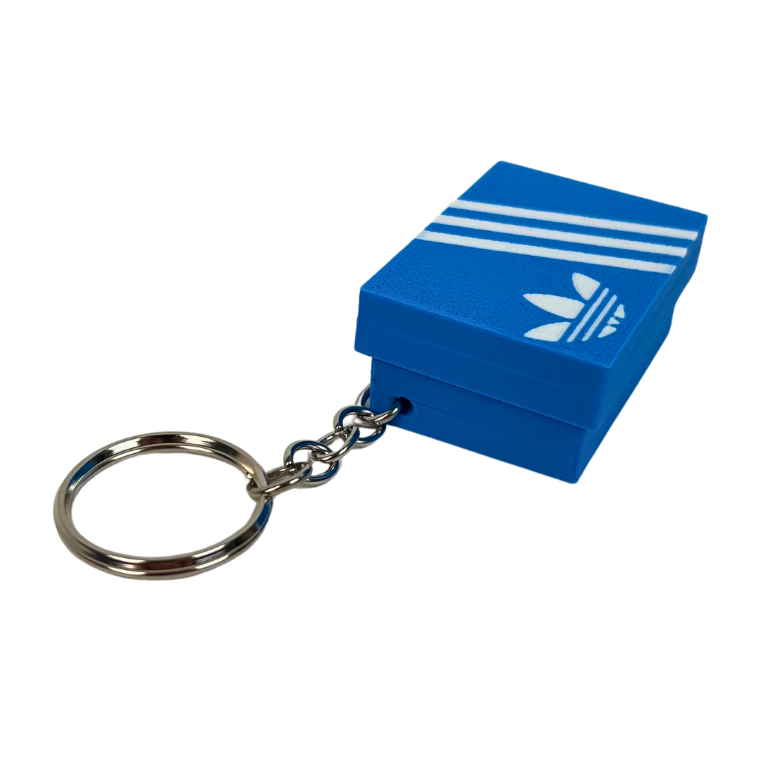 Llavero clicker Beetle Print azul con diseño Retro Stripes mostrado en perspectiva para apreciar la forma de la caja miniatura