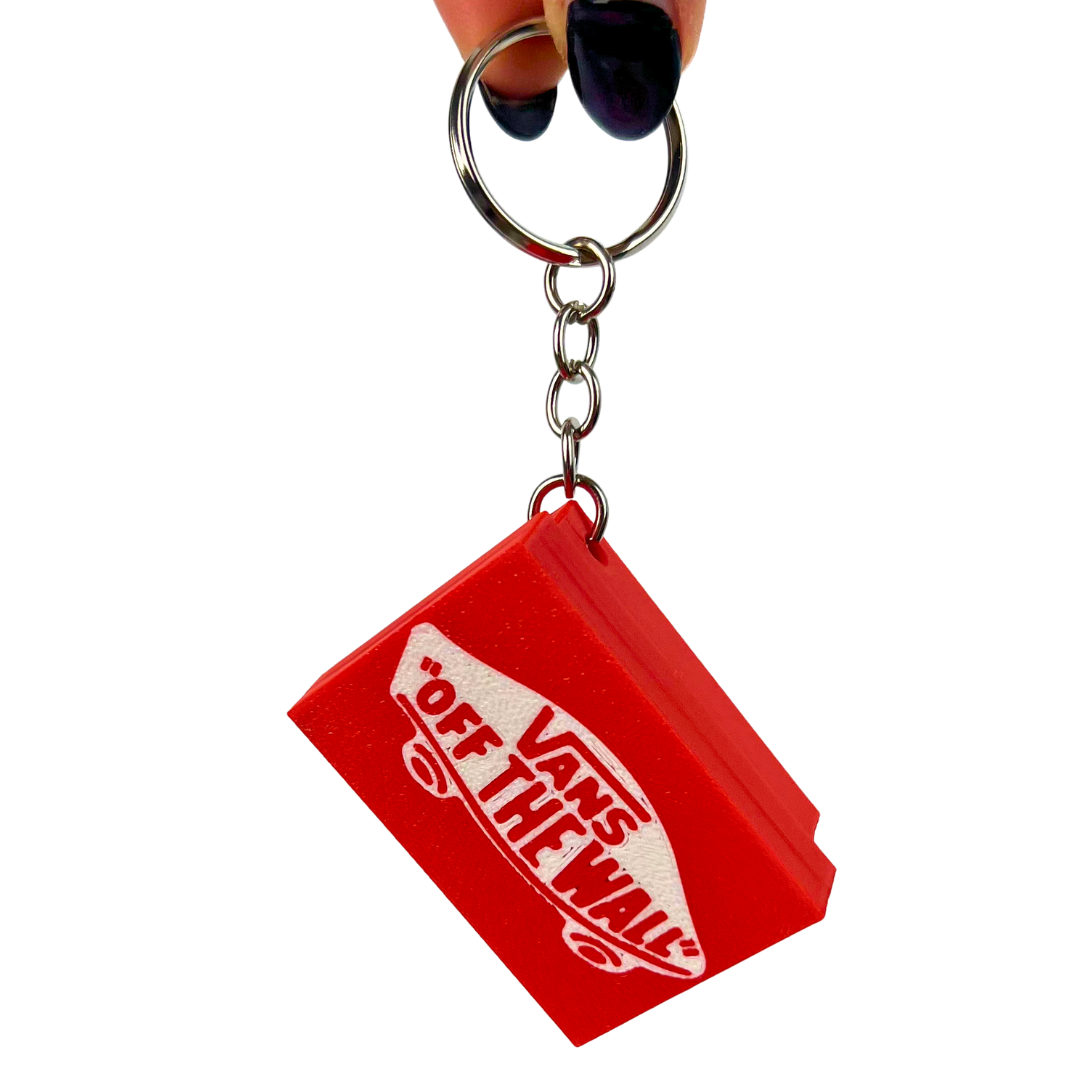 Llavero clicker Beetle Print Skate Classic colgado para mostrar su tamaño compacto, cadena metálica y uso como accesorio