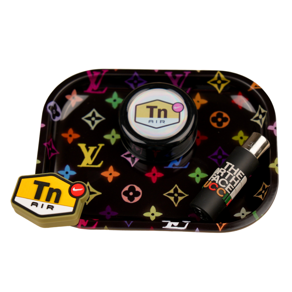Pack de accesorios Beetle Print con bandeja de diseño monograma multicolor sobre fondo negro, grinder Zero con acabado holográfico, recipiente de silicona con diseño geométrico y funda para mechero negra personalizada con detalles gráficos contemporáneos.