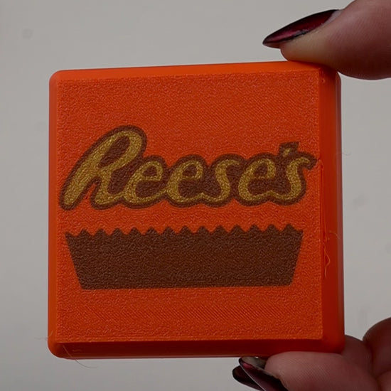 fidget antiestrés beetle print peanut cup en uso presionando boton clicker