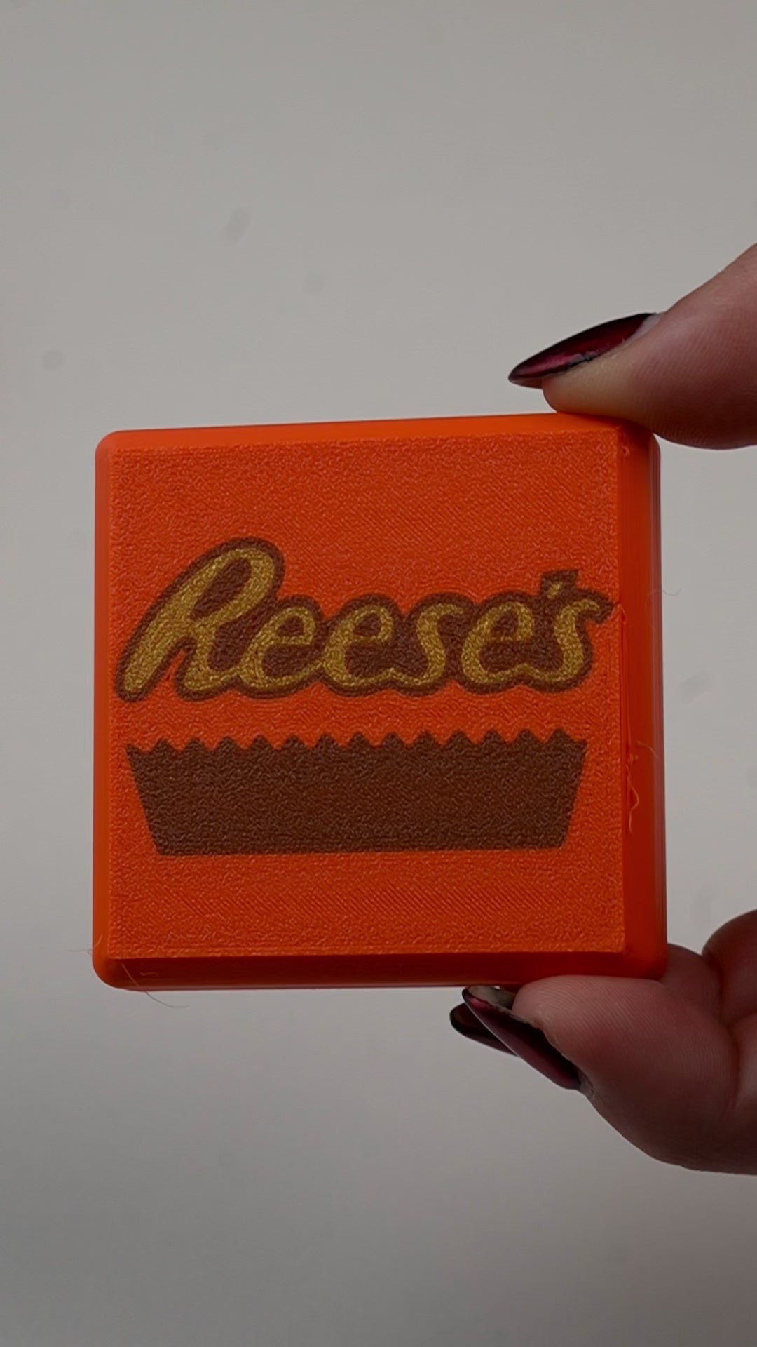 fidget antiestrés beetle print peanut cup en uso presionando boton clicker