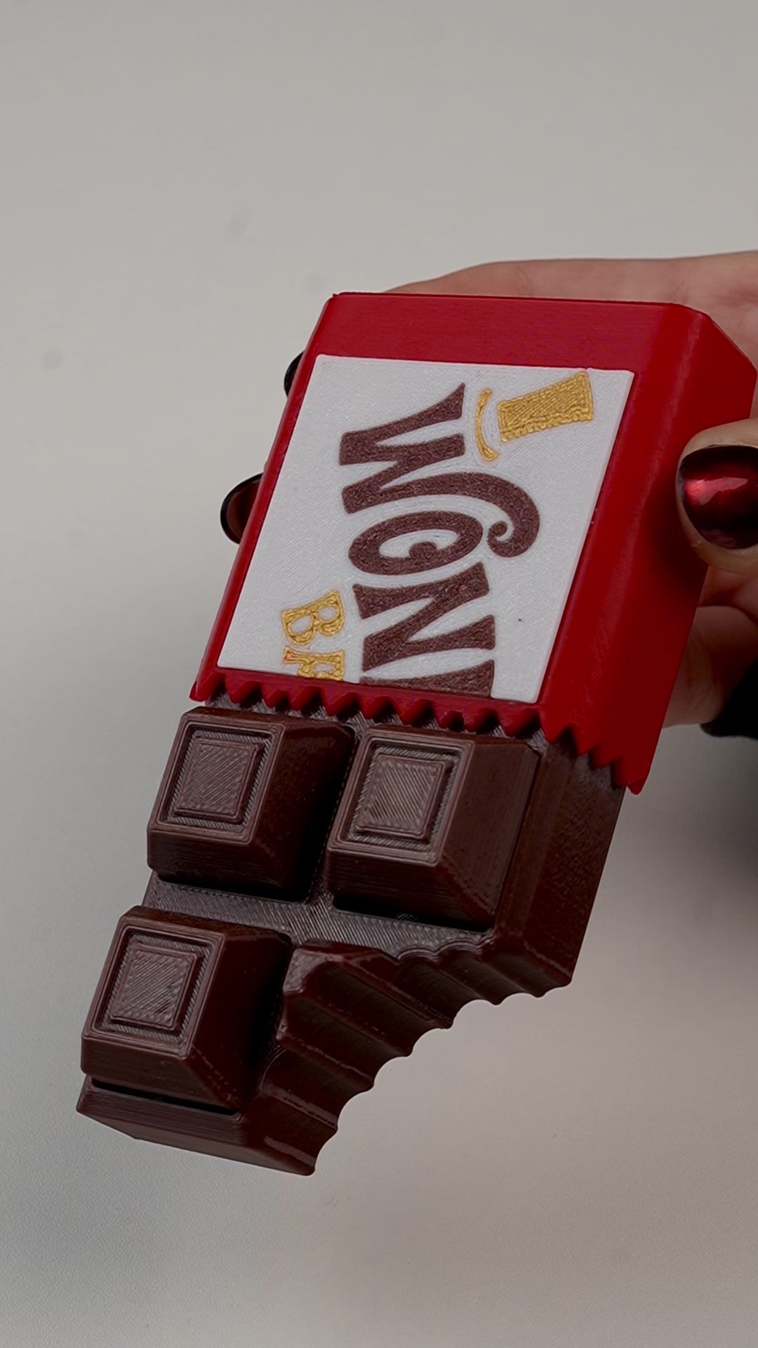 fidget antiestrés beetle print chocolate en uso presionando boton clicker