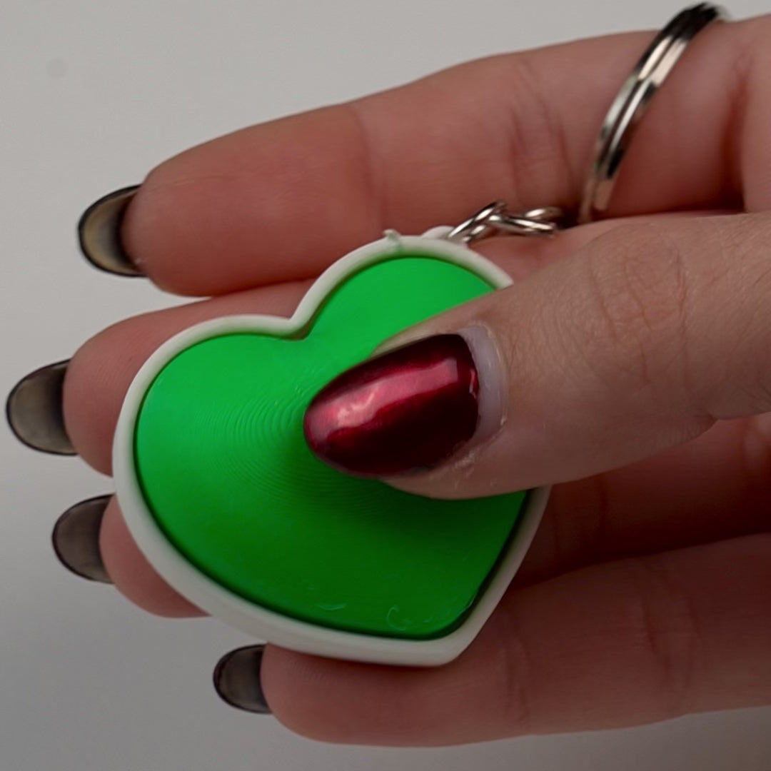 llavero fidget antiestrés beetle print corazón en uso presionando boton