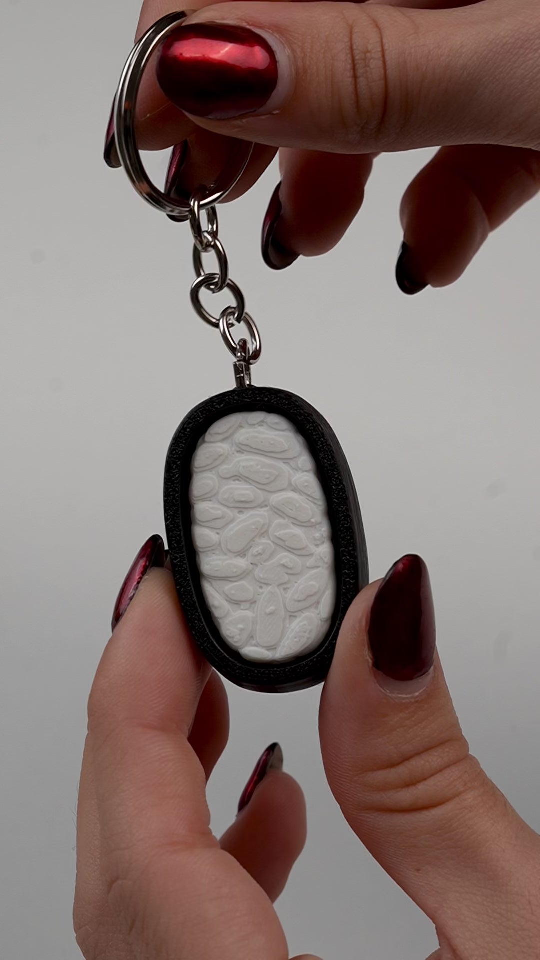 llavero antiestrés beetle print sushi en uso presionando boton clicker