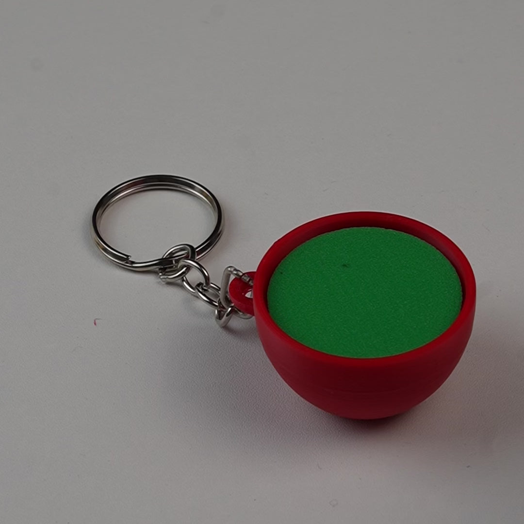 llavero antiestrés beetle print taza de té verde en uso presionando boton clicker